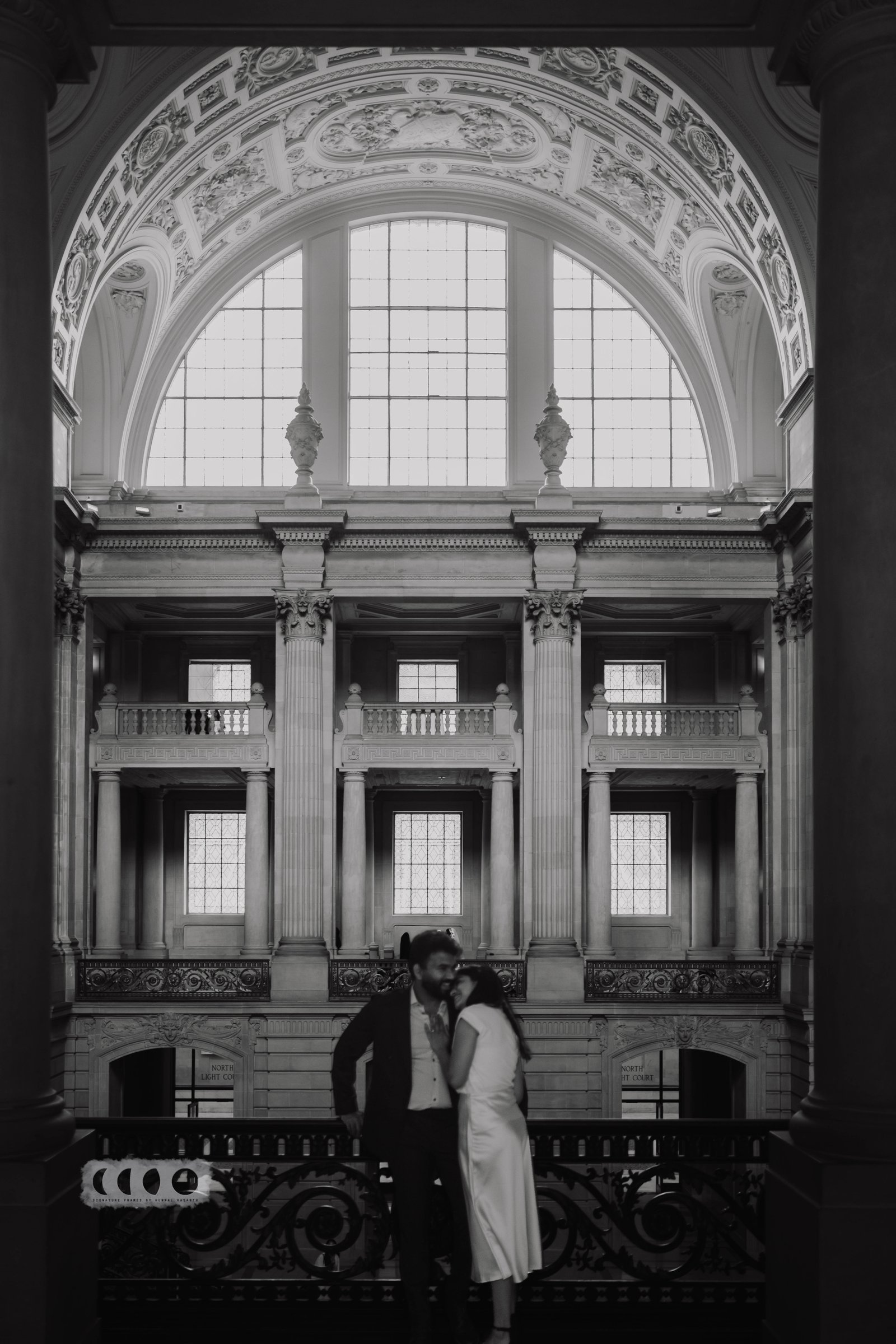 A black and white portrait framed by a grand arched window